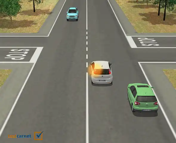 El vehículo blanco va a girar a la izquierda; el conductor del vehículo verde, ¿puede circular por el arcén para adelantarlo por la derecha?